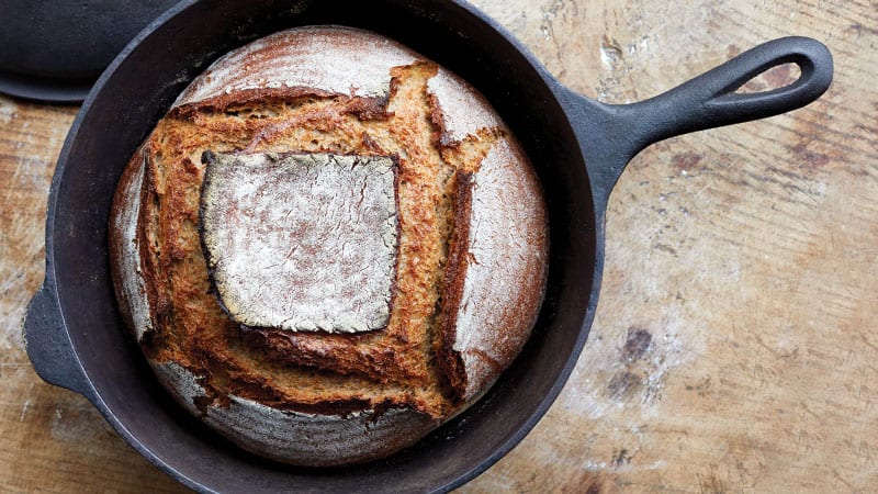 Beauty shot of sourdough bread in a cast iron pan. Photo credit: Jim Henkens/Sasquatch Books