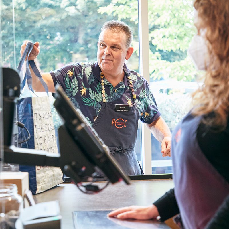 Dennis handing a bag to a customer