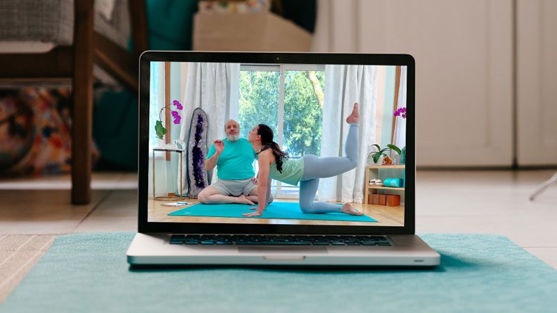 virtual yoga class streaming on laptop computer