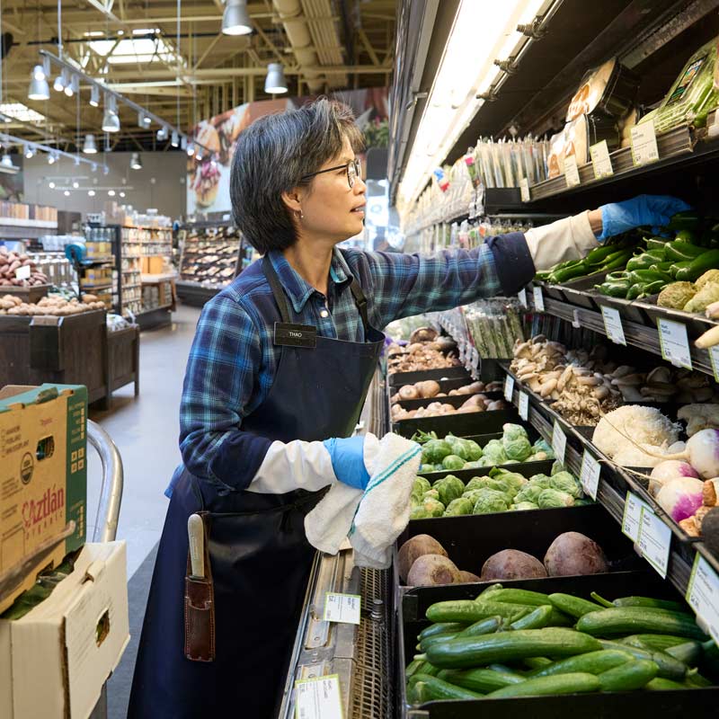 Thao stocking the produce wet rack