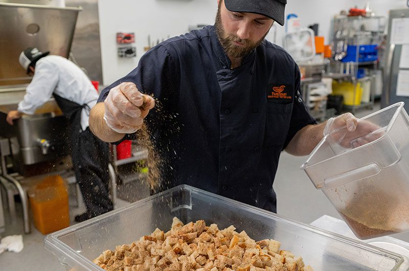 Farestart croutons being seasoned